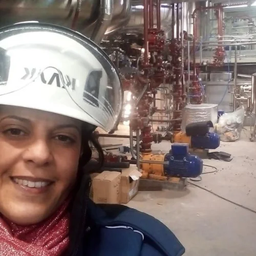 Chemical Engineer Mentor, Ivet Miranda inside a real industrial plant, surrounded by process equipment and pipelines.